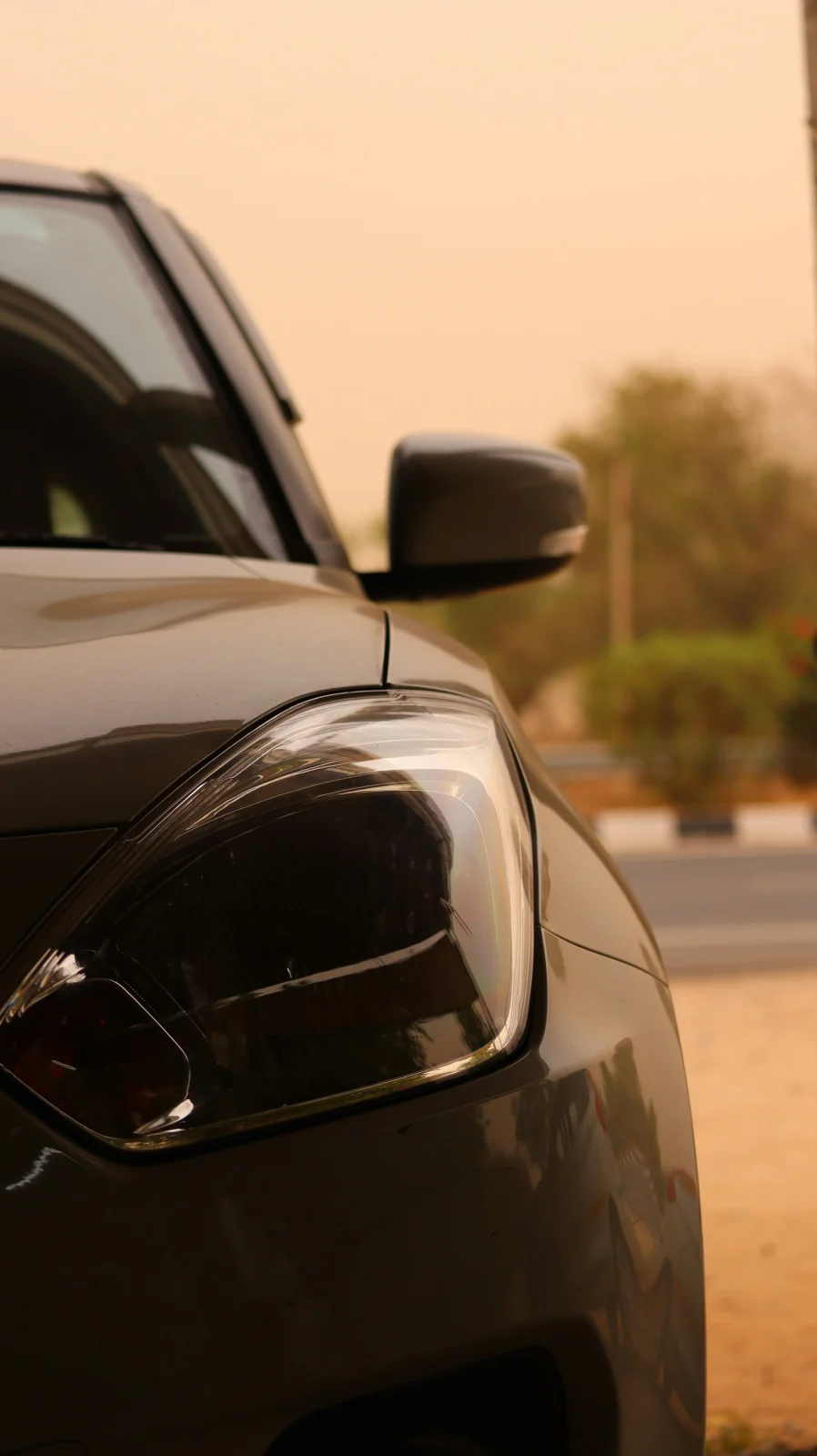 Close-up of a car headlight and mirror in the warm evening light in Jaipur